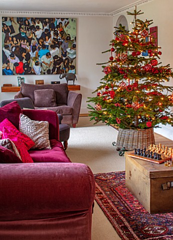 GIBBONS_CROFT_WEST_CLANDON_SURREY_CHRISTMAS__SITTING_ROOM_RED_SOFAS_PAINTING_BY_FAMILY_FRIEND_CHRIST