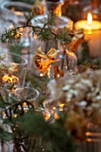 GIBBONS CROFT, WEST CLANDON, SURREY: CHRISTMAS. OPEN PLAN KITCHEN, DINING ROOM. TABLE DECORATIONS. GLASSWARE, CANDLES, PINE, DRIED HYDRANGEAS, ROSES