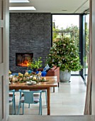 GIBBONS CROFT, WEST CLANDON, SURREY: OPEN PLAN KITCHEN, DINING ROOM. SLATE WALL, FIREPLACE, TABLE, CHAIRS, CHRISTMAS TREE