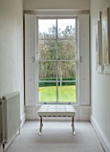 GIBBONS CROFT, WEST CLANDON, SURREY: UPPER HALL, VIEW ONTO GARDEN, SASH WINDOW, WHITE LEATHER AND CHROME FOOT STOOL