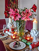 THE CONIFERS, OXFORDSHIRE: CHRISTMAS - KITCHEN DINING ROOM - TABLE, CHAIRS, PRINT OF RED CAMELLIA BY CLIVE NICHOLS, VASE WITH AMARYLLIS, PINEAPPLE CANDLES, CRACKERS