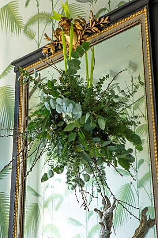 BUTTER_WAKEFIELD_HOUSE_LONDON_CHRISTMAS__THE_HALLWAY_WITH_MIRROR_AND_HANGING_DISPLAY_WITH_EUCALYPTUS