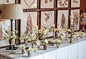 WARDINGTON MANOR, OXFORDSHIRE: FLORIST SHANE CONNOLLY - DINING ROOM: CANDLES, VASES, CONTAINERS WITH CHRISTMAS ROSE, HELLEBORES, INDOOR, FLOWERS