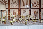 WARDINGTON MANOR, OXFORDSHIRE: FLORIST SHANE CONNOLLY - DINING ROOM: CANDLES, VASES, CONTAINERS WITH CHRISTMAS ROSE, HELLEBORES, INDOOR, FLOWERS