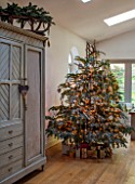 MERRYWOOD, JACKY HOBBS HOUSE, LONDON: SITTING ROOM - FRENCH VINTAGE CUPBOARD, WOODEN SLEIGH, CHRISTMAS TREE, DECORATIONS