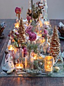 MERRYWOOD, JACKY HOBBS HOUSE, LONDON: SITTING ROOM - DINING AREA, WOODEN DINING TABLE, CANDLES, METAL CROWNS, CHRISTMAS TREE, PLACE SETTINGS, METAL GOBLETS, DRIED PEONY AND ROSES