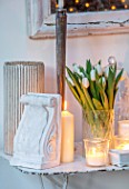MERRYWOOD, JACKY HOBBS HOUSE, LONDON: DINING ROOM - VINTAGE FRENCH METAL GARDEN TABLE, VINTAGE PLASTER ARTEFACTS, WHITE CANDLES, WHITE TULIPS IN VASE