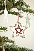 MERRYWOOD, JACKY HOBBS HOUSE, LONDON: DETAIL OF DIAMANTE STAR CHRISTMAS TREE DECORATION ON CHRISTMAS TREE WITH METAL STARS