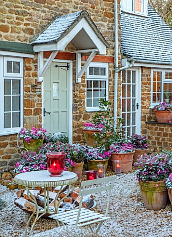 THE_CONIFERS_OXFORDSHIRE_FRONT_OF_THE_HOUSE_SNOW_CONTAINERS_WITH_CYCLAMEN_SKIMMIA_CANDLES_PATIO_GRAV