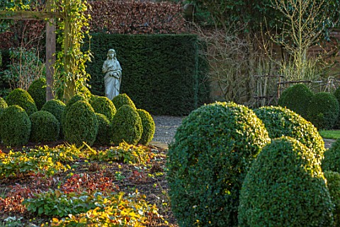 MORTON_HALL_WORCESTERSHIRE_CLIPPED_TOPIARY_BOX_BALLS_BESIDE_GRAVEL_DRIVE_STATUE_WINTER_FEBRUARY_ENGL