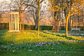 MORTON HALL, WORCESTERSHIRE: WHITE AND PURPLE CROCUS IN THE PARKLAND MEADOW. CROCUSES, CROCI, FEBRUARY, MEADOWS, NATURALISED, MASSES, BENCHES, SEATS, MONOPTEROS