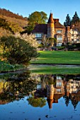 LITTLE MALVERN COURT, WORCESTERSHIRE: THE COURT REFLECTED IN LAKE, SPRING, LAKES, WATER, PONDS, POOLS, REFLECTIONS, MAGNOLIA X SOULANGEANA ALBA SUPERBA