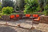 TAROUDANT, MOROCCO: DESIGNERS ARNAUD MAURIERES AND ERIC OSSART: TERRACE, SEATING AREA, TABLES, CHAIRS, LOUNGERS, ORANGE CUSHIONS