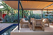 TAROUDANT, MOROCCO: DESIGNERS ARNAUD MAURIERES AND ERIC OSSART: BED OF AGAVES, SUCCULENTS, DRY, ARID, GARDENS, SEATING AREA, CANOPY, AWNING, RILL, WATER, TABLE, CHAIRS