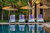 TAROUDANT, MOROCCO: DESIGNERS ARNAUD MAURIERES AND ERIC OSSART: SWIMMING POOL, WATER, SUNLOUNGERS, TOWELS, CANOPY, SUN LOUNGERS, PURPLE, BLUE