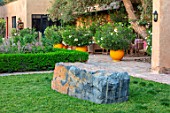 TAROUDANT, MOROCCO: DESIGNERS ARNAUD MAURIERES AND ERIC OSSART: GARDEN WITH GRASS, LAWN, ROCK, ROCKS, TERRACE, GLAZED YELLOW CONTAINERS, OLEANDERS