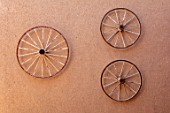 TAROUDANT, MOROCCO: DESIGNERS ARNAUD MAURIERES AND ERIC OSSART: OLD CART WHEELS ON MUD WALL AT ENTRANCE TO THE GARDEN