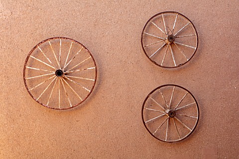 TAROUDANT_MOROCCO_DESIGNERS_ARNAUD_MAURIERES_AND_ERIC_OSSART_OLD_CART_WHEELS_ON_MUD_WALL_AT_ENTRANCE