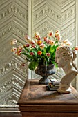 THE LAND GARDENERS, WARDINGTON MANOR, OXFORDSHIRE: TULIPS ARRANGED IN METAL CONTAINER ON WOODEN TABLE. STATUE, SPRING, ARRANGEMENT, CUTTING