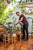 JAMIES JUNGLE, LONDON HOUSE OF JAMIE SONG: APARTMENT FILLED WITH HOUSEPLANTS. INDOORS, GREEN INTERIORS,  JAMIE SONG WATERING