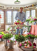 THE LAND GARDENERS, WARDINGTON MANOR, OXFORDSHIRE: CLIVE NICHOLS WITH FLOWERS IN THE FLOWER ROOM. CUTTING, CONSTANCE SPRY VASES