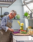 CLAUS DALBY GARDEN, DENMARK: CLAUS CHOPPING UP RED CABBAGE IN HIS OUTDOOR KITCHEN