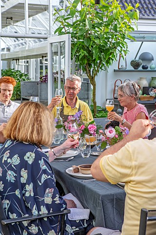 CLAUS_DALBY_GARDEN_DENMARK_CLAUS_AND_FRIENDS_EATING_AT_A_TABLE_ON_PATIO