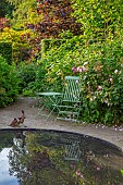 CLAUS DALBY GARDEN, DENMARK: CIRCULAR POOL, POND, WATER, REFLECTIONS, REFLECTED, TABLE, CHAIRS, SUMMER