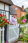 THATCH COTTAGE, WORCESTERSHIRE: OWNER MARY COX AT THE WHITE FRONT GATE OF HER COTTAGE