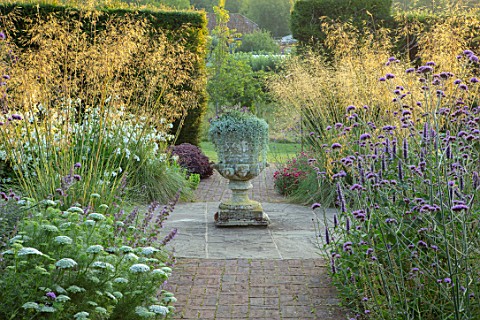 GLYNDEBOURNE_EAST_SUSSEX_PATH_BORDERS_URN_STONE_CONTAINER_PLANTED_WITH_DICHONDRA_SILVER_FALLS_STIPA_
