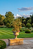 PRIVATE GARDEN, GLOUCESTERSHIRE - DESIGNER ANGEL COLLINS: TERRACE, URN, CONTAINER LOOKING OUT TO PARKLAND, AUGUST