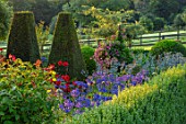 PETTIFERS, OXFORDSHIRE, DESIGNER GINA PRICE: THE PARTERRE IN AUGUST - DAHLIA MURDOCH AND AGAPANTHUS HEADBOURNE HYBRIDS, YEW, MORNING LIGHT, SUNRISE