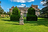 CANONS ASHBY, NORTHAMPTONSHIRE, THE NATIONAL TRUST: GREEN COURT, THE HOUSE, YEW TOPIARY, LEAD STATUE OF SHEPHERD BOY FROM A MODEL BY JAN VON NOST