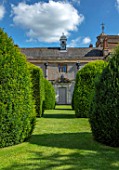 CANONS ASHBY, NORTHAMPTONSHIRE, THE NATIONAL TRUST: GREEN COURT,  THE WEST FRONT, DOOR, COAT OF ARMS CAST IN LEAD, YEW TOPIARY