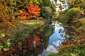 THORP PERROW ARBORETUM, YORKSHIRE: POOL, POND, LAKE WITH HERON SCULPTURE AND AUTUMN COLOUR OF JAPANESE MAPLES, ACERS, FALL