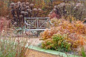 THE OLD RECTORY, QUINTON, NORTHAMPTONSHIRE: DESIGNER ANOUSHKA FEILER: GRASSES, AUTUMN, FALL, WOODEN BENCH, SEAT, FROST, FROSTY, EUPHORBIA WALLICHII