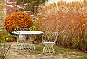 THE OLD RECTORY, QUINTON, NORTHAMPTONSHIRE: DESIGNER ANOUSHKA FEILER: TABLE, CHAIRS, MISCANTHUS SINENSIS KLEINE FONTAINE, PATIOS, AUTUMN, FALL, FAGUS SYLVATICA