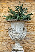 DAYLESFORD ORGANIC, GLOUCESTERSHIRE: CHRISTMAS: WHITE URN, CONTAINER WITH SPRUCE CHRISTMAS DECORATIONS, WALL, WINTER