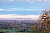 MORTON HALL GARDENS, WORCESTERSHIRE: VIEW TO ABBERLEY HILLS AT DAWN. SUNRISE, WINTER, JANUARY, LANDSCAPE