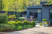 LITTLE ORCHARDS, SURREY, DESIGNER NIC HOWARD: DRIVE, HOME OFFICE, CLIPPED BOX HEDGES, HEDGING, TABLE, CHAIRS, METAL CONTAINER WITH TULIPS, SPRING, APRIL