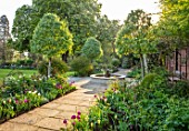 MORTON HALL GARDENS, WORCESTERSHIRE: TULIPS AND FOUNTAIN IN THE SOUTH GARDEN, APRIL, SPRING, PATHS, MORNING LIGHT