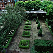 SQUARE BOX HEDGES & BOX DOMES. CONICAL BOX IN VERSAILLE TUBS IN AREA OF BRICKS & PAVING STONES. DESIGNER: VICTOR SHANLEY