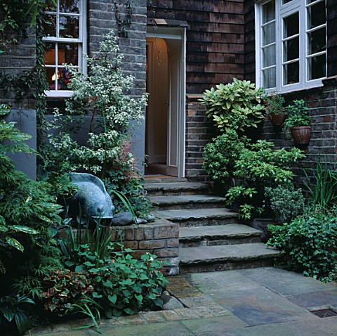 TINY_FOUNTAIN_AND_POOL_TUCKED_BESIDE_SHALLOW_STEPS_LEADING_TO_BACK_DOOR_DESIGNER_JILL_BILLINGTON