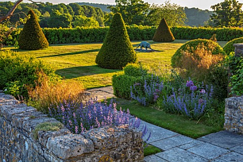 FONTHILL_HOUSE_GARDENS_GARDEN_WITH_YEW_PYRAMIDS_SCULPTURE_STIPA_GIGANTEA_SPRING_MAY_SUNSET