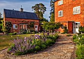MORTON HALL, WORCESTERSHIRE: WEST GARDEN, EVENING, HOUSE, BORDERS, BEDS, IRISES, PATH, COUNTRY, GARDEN, ENGLISH, CLASSIC