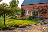 MORTON HALL, WORCESTERSHIRE: TERRACE, PAVING, ERIGERON ANNUUS, THYMES, THYMUS SERPHYLLUM RUSSETINGS, CLEMATIS, LAWN, JUNE, SUMMER