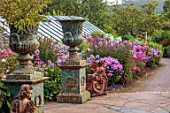 LARCH COTTAGE NURSERIES, CUMBRIA: URNS, CONTAINERS, BORDER OF PHLOX, BORDERS, ORNAMENTS, FORMAL, PINK FLOWERS, SUMMER, GREENHOUSE