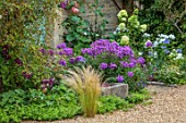 THE MANOR HOUSE, STEVINGTON, BEDFORDSHIRE. DESIGNER: KATHY BROWN - GRAVEL, CONTAINER PLANTED WITH HYDRANGEA LIMELIGHT, TROUGH, PHLOX , BLUE DOORWAY, DOOR, FRONT