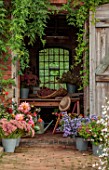 THE FLOWER GARDEN AT STOKESAY COURT: THE POTTING SHED WITH DAHLIAS, SEDUMS, ASTERS AND HYDRANGEAS IN CONTAINERS