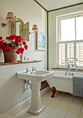 ASHBROOK HOUSE, NORTHAMPTONSHIRE: BATHROOM WITH PINK GERANIUMS IN TERRACOTTA CONTAINER